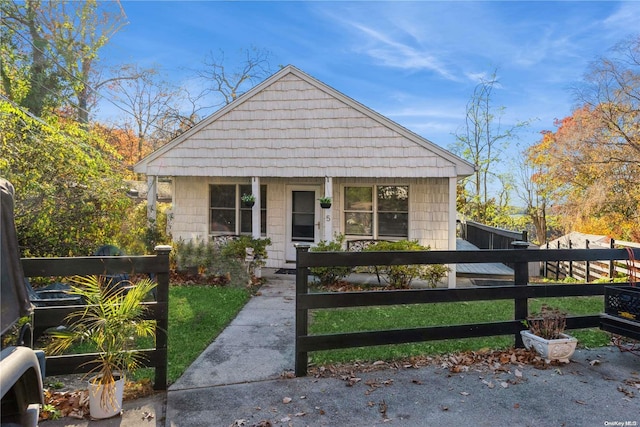 bungalow featuring a front lawn