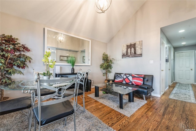 living room featuring dark hardwood / wood-style flooring, high vaulted ceiling, and a chandelier