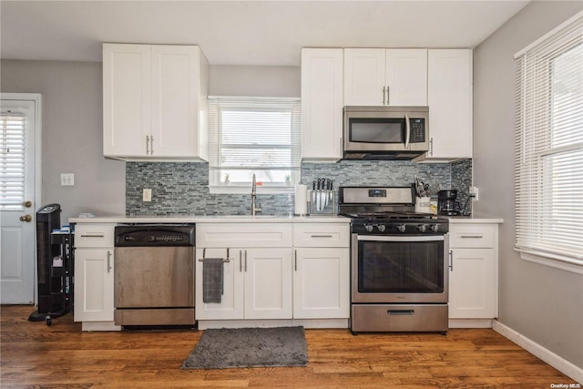 kitchen featuring a wealth of natural light, white cabinets, and appliances with stainless steel finishes