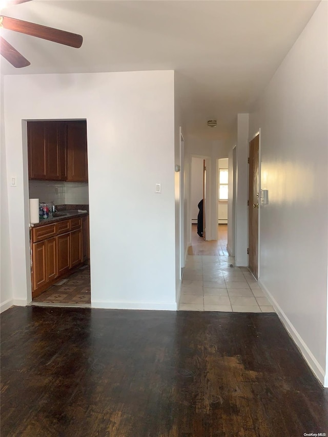 corridor with hardwood / wood-style floors and sink