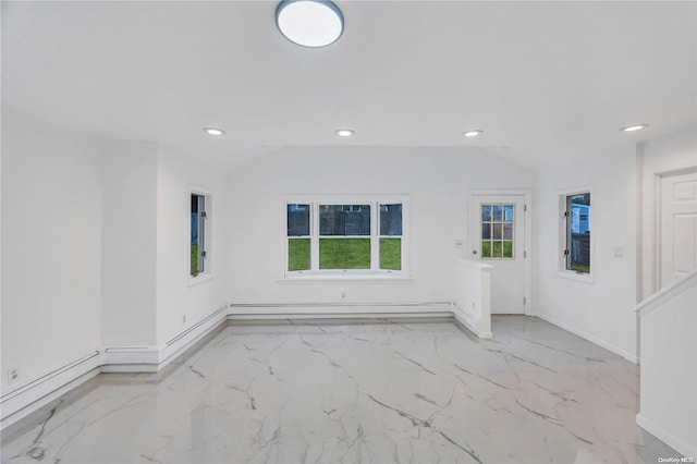 empty room with baseboard heating and lofted ceiling