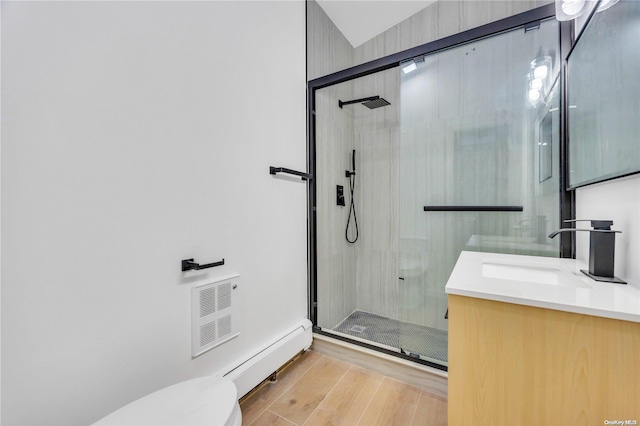 bathroom with baseboard heating, an enclosed shower, toilet, vanity, and hardwood / wood-style flooring