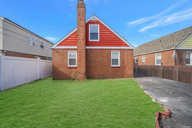 rear view of property with a yard