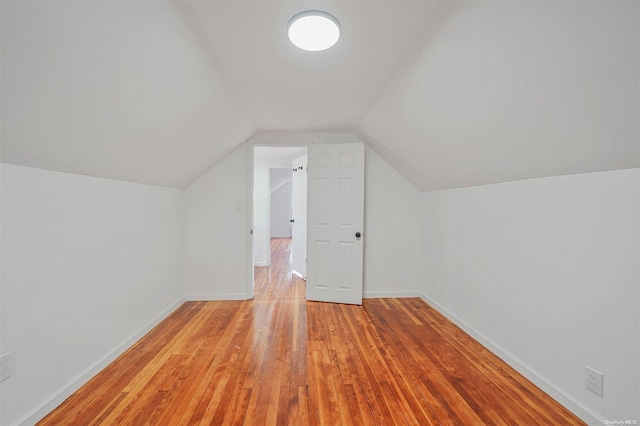 additional living space featuring lofted ceiling and light hardwood / wood-style flooring