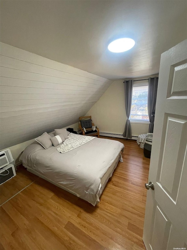 bedroom featuring light hardwood / wood-style floors and vaulted ceiling