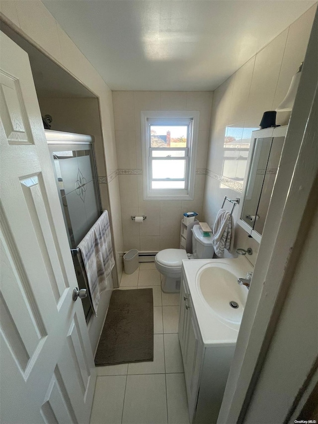 bathroom featuring tile patterned flooring, vanity, toilet, and tile walls