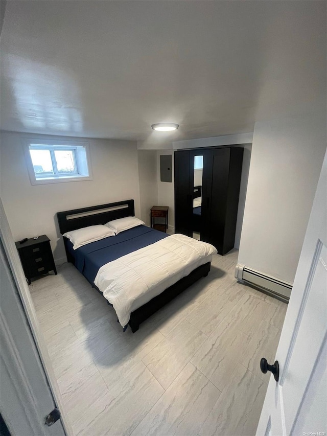 bedroom featuring baseboard heating and electric panel