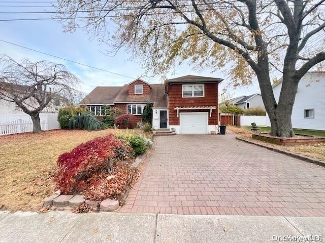 view of front of house featuring a garage and a front lawn