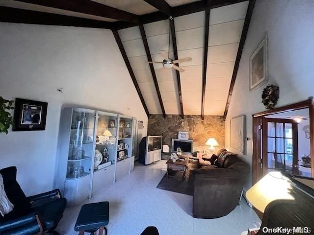 living room featuring beam ceiling, high vaulted ceiling, and ceiling fan