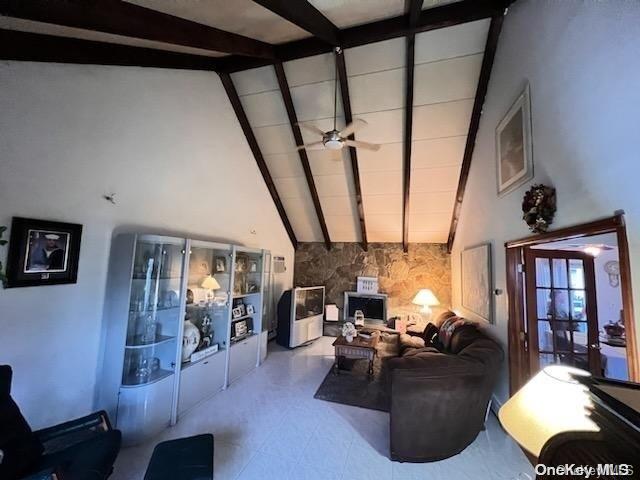 living room featuring ceiling fan, beamed ceiling, and high vaulted ceiling