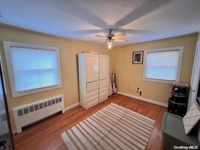 sitting room with hardwood / wood-style floors, ceiling fan, and radiator