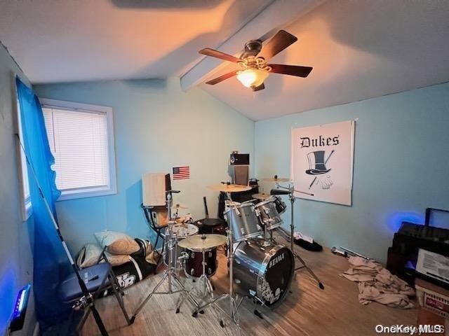 interior space featuring vaulted ceiling with beams, ceiling fan, and wood-type flooring