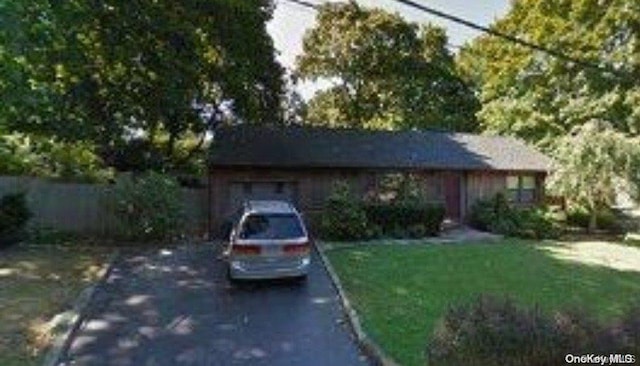 view of front of property with a garage and a front lawn