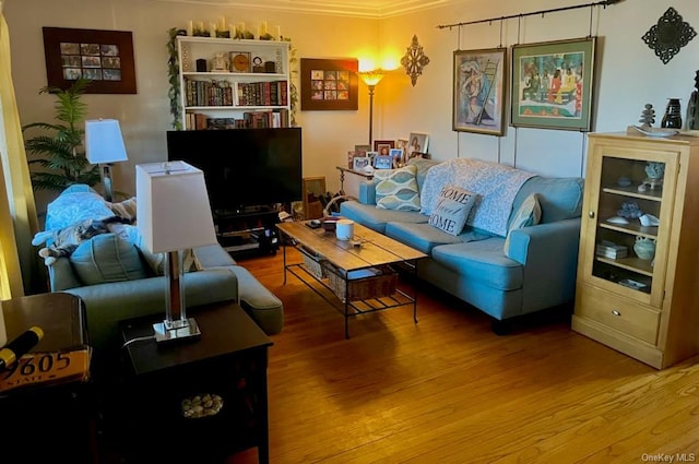 living room featuring wood-type flooring and ornamental molding