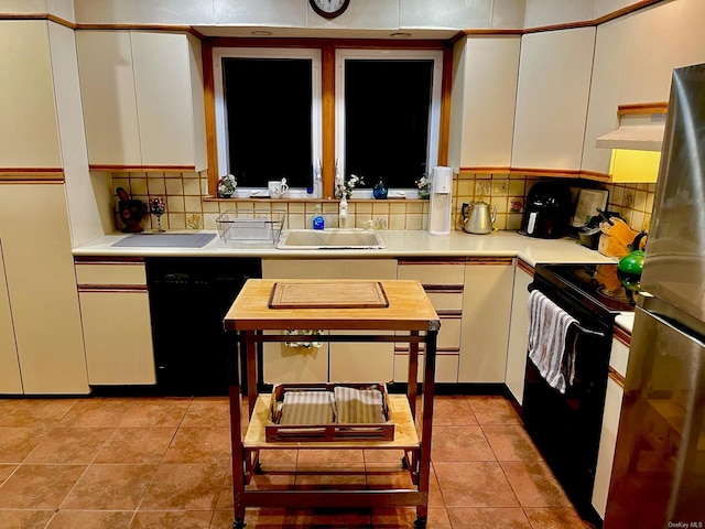 kitchen with light tile patterned flooring, white cabinetry, sink, decorative backsplash, and black appliances