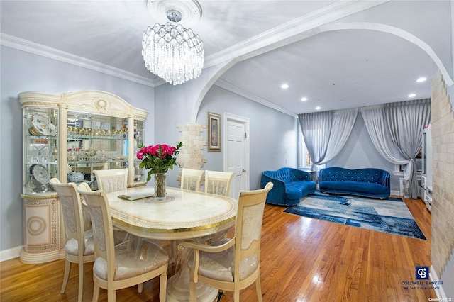 dining space featuring crown molding, hardwood / wood-style floors, and a notable chandelier