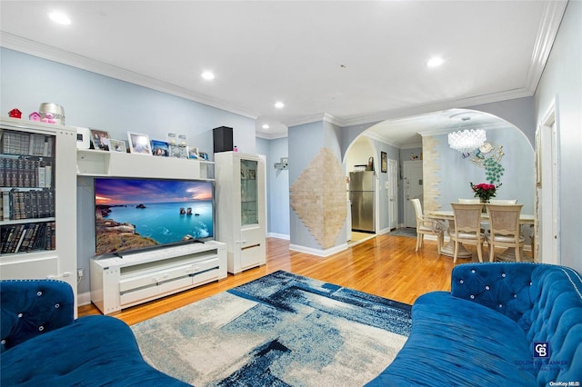 living room with crown molding, hardwood / wood-style floors, and an inviting chandelier