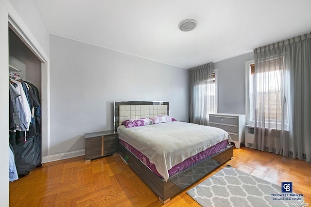 bedroom featuring light parquet floors and a closet