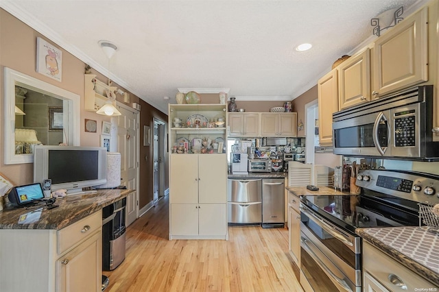 kitchen featuring light wood-type flooring, dark stone counters, ornamental molding, and appliances with stainless steel finishes