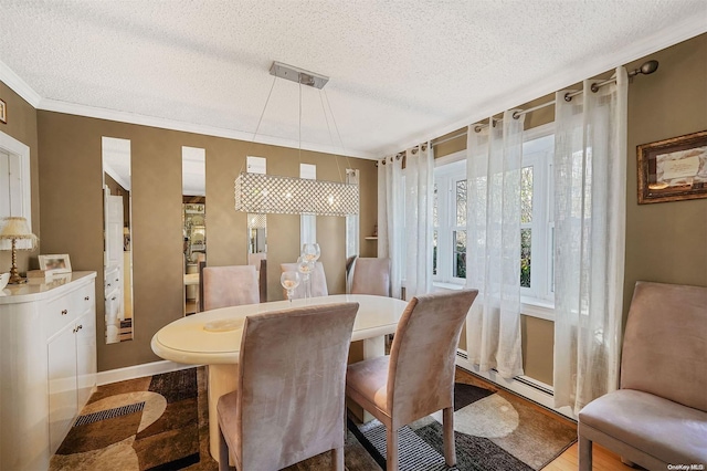 dining room featuring a baseboard heating unit, a textured ceiling, and crown molding