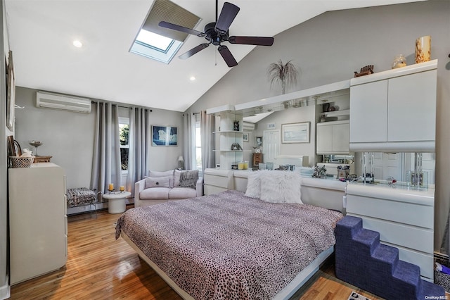 bedroom with lofted ceiling with skylight, a baseboard heating unit, ceiling fan, light hardwood / wood-style flooring, and a wall mounted air conditioner