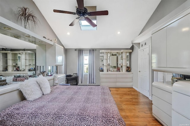 bedroom with vaulted ceiling, ceiling fan, light hardwood / wood-style floors, and washer / clothes dryer