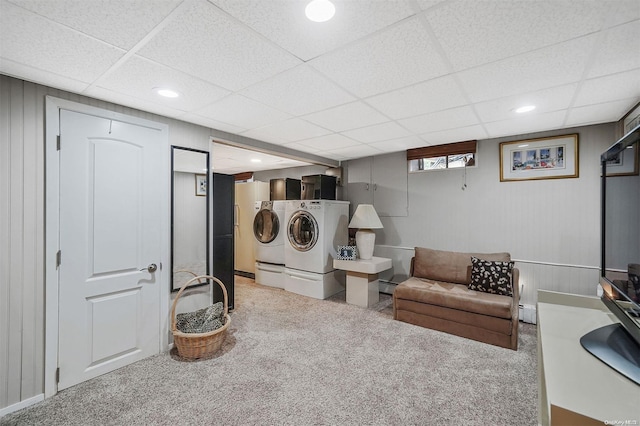 laundry area with baseboard heating, light colored carpet, and washing machine and clothes dryer