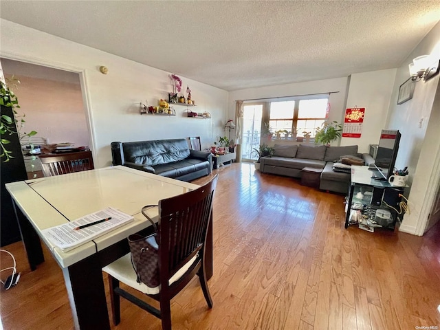 dining space with hardwood / wood-style flooring and a textured ceiling