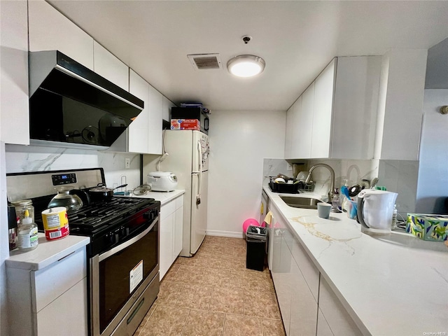 kitchen with backsplash, stainless steel gas range oven, extractor fan, sink, and white cabinetry