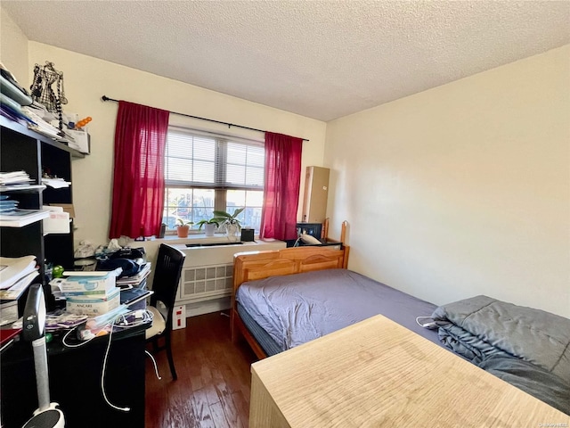 bedroom featuring a textured ceiling and dark hardwood / wood-style floors