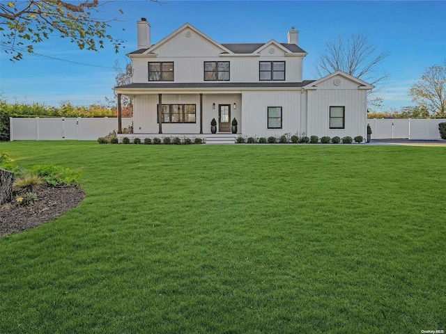 modern farmhouse style home with a front yard and a porch