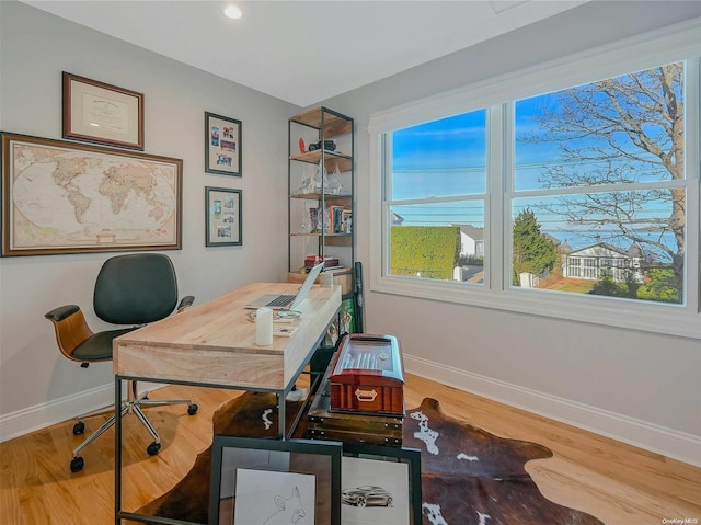 home office with hardwood / wood-style flooring and a healthy amount of sunlight