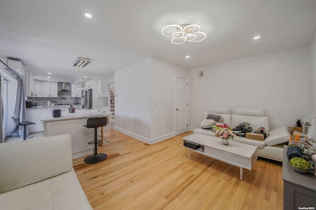 living room with light wood-type flooring and an AC wall unit