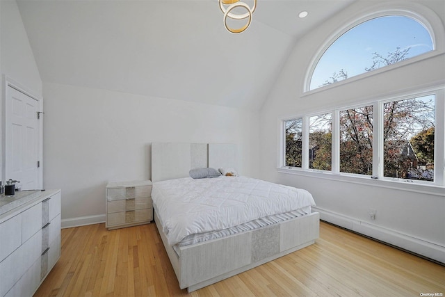 bedroom with lofted ceiling and light wood-type flooring