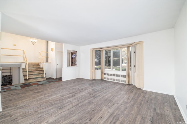 unfurnished living room featuring radiator and dark hardwood / wood-style flooring