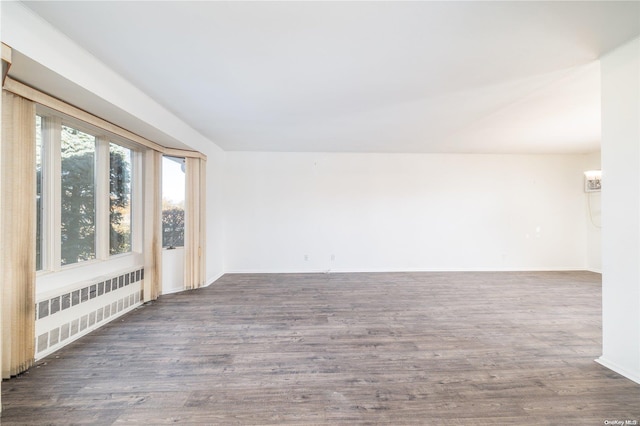 spare room with radiator and dark wood-type flooring