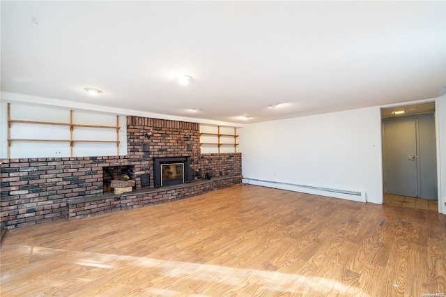 unfurnished living room featuring light hardwood / wood-style floors, baseboard heating, and brick wall