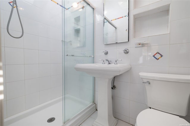 bathroom featuring toilet, tile walls, and walk in shower