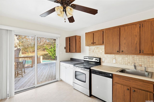 kitchen with white dishwasher, tasteful backsplash, sink, stainless steel electric stove, and ceiling fan