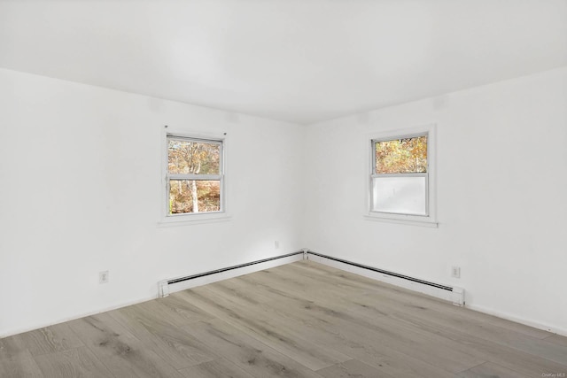 spare room with a baseboard radiator, light hardwood / wood-style floors, and a healthy amount of sunlight