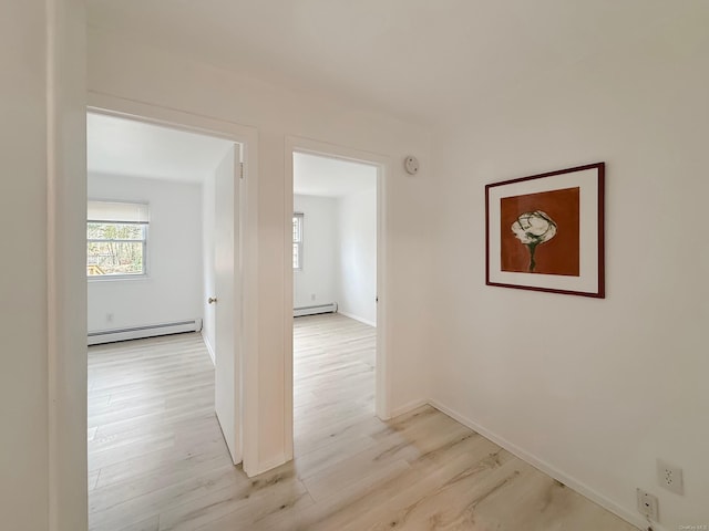 corridor with a baseboard radiator and light wood-type flooring