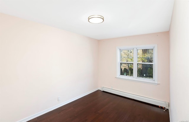 spare room with wood-type flooring and a baseboard radiator