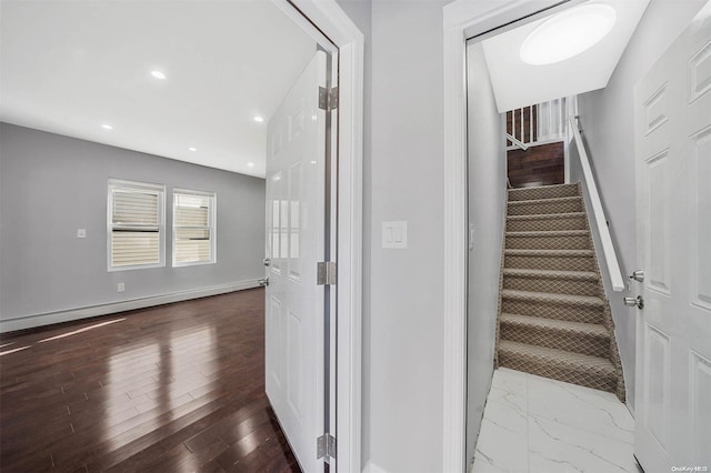 staircase with a baseboard radiator and hardwood / wood-style flooring