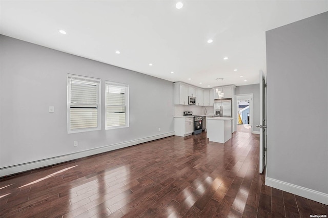 unfurnished living room featuring dark hardwood / wood-style flooring and a baseboard heating unit