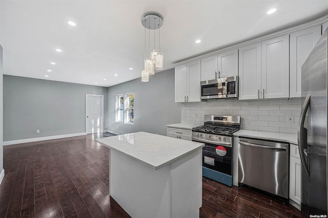 kitchen with pendant lighting, a center island, white cabinets, dark hardwood / wood-style floors, and stainless steel appliances