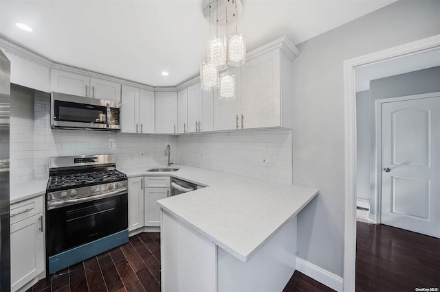 kitchen with dark hardwood / wood-style flooring, white cabinetry, pendant lighting, and stainless steel appliances