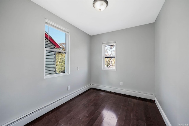 spare room featuring a baseboard radiator and dark wood-type flooring