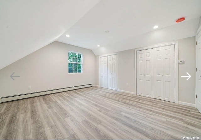 bonus room with light wood-type flooring, lofted ceiling, and a baseboard heating unit