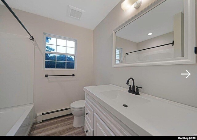 full bathroom with shower / bathtub combination, vanity, a baseboard heating unit, hardwood / wood-style floors, and toilet