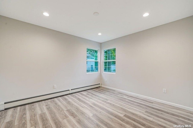 spare room with light wood-type flooring and baseboard heating